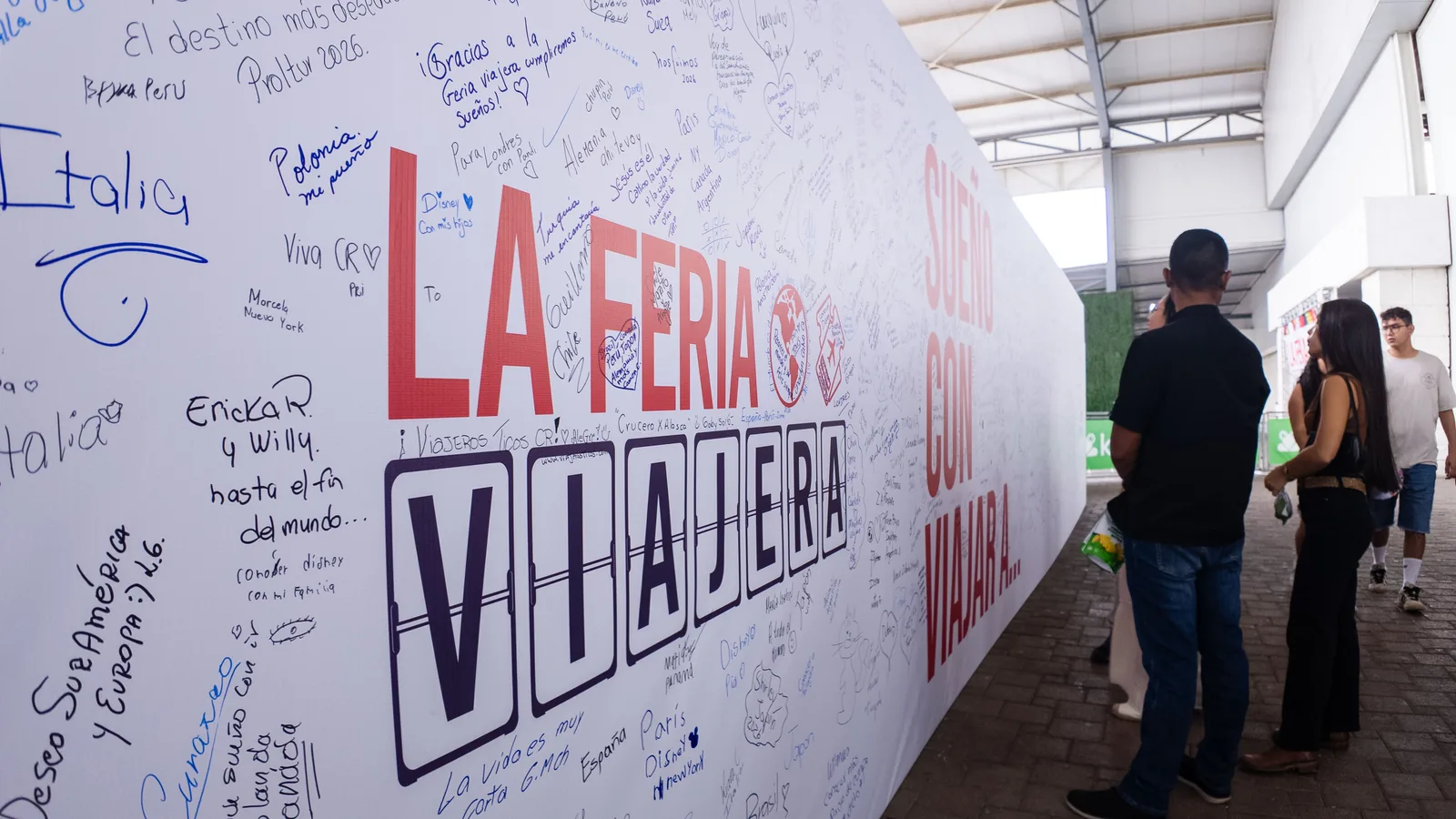 Mural blanco de La Feria Viajera cubierto de destinos escritos a mano por los visitantes