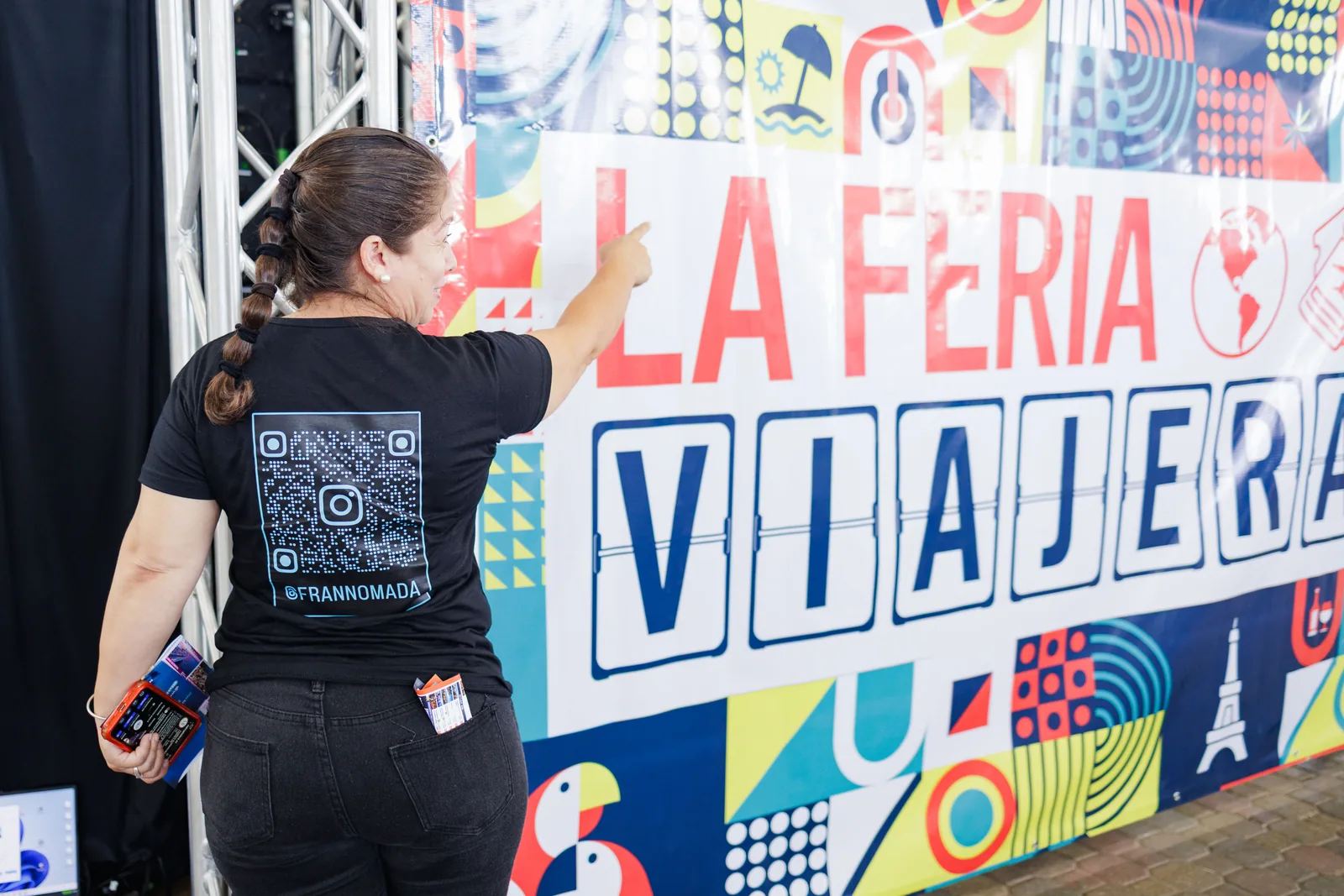 Integrante del equipo firmando el mural con el logo de La Feria Viajera